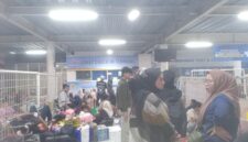Penumpang memenuhi area Terminal Dharma Ferry Pelabuhan Makassar sambil menunggu pembukaan loket check in. Minimnya kursi membuat sebagian penumpang terpaksa duduk di lantai.