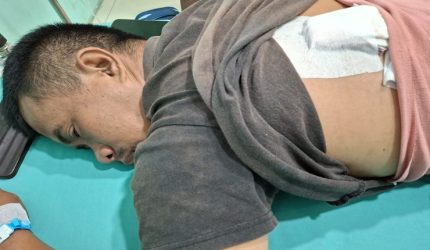 Kondisi Rahmat Saputra (36), pedagang korban pembacokan di Percut Sei Tuan, saat menjalani perawatan medis dengan perban penutup luka jahitan di punggungnya.