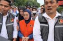 Mantan Bupati Gowa, Sitti Husniah Talenrang menggunakan rompi oranye dan kedua tangan diborgol tali tis usai keluar dari ruang penyidikan (Foto : Ist)