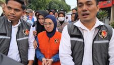 Mantan Bupati Gowa, Sitti Husniah Talenrang menggunakan rompi oranye dan kedua tangan diborgol tali tis usai keluar dari ruang penyidikan (Foto : Ist)