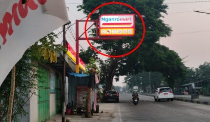 Papan reklame neon box Nganro Mart di Pekkae, Kabupaten Barru, tampak berdiri menjorok dan "offside" melewati batas bahu Jalan Trans Sulawesi, memicu kekhawatiran para pengemudi truk karena posisinya sangat rawan tersenggol kendaraan berat.